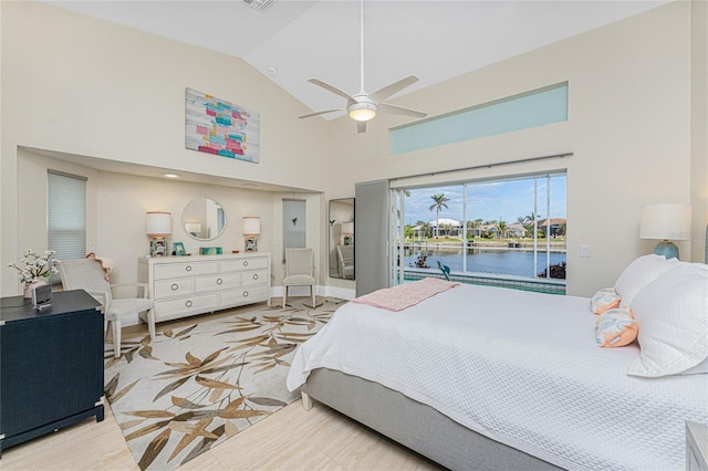 bedroom featuring a water view, ceiling fan, access to exterior, and high vaulted ceiling