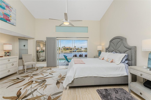 bedroom with a water view, high vaulted ceiling, access to exterior, and ceiling fan