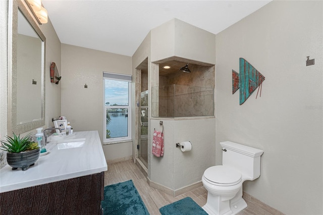 bathroom with toilet, a water view, vanity, a shower with door, and hardwood / wood-style floors