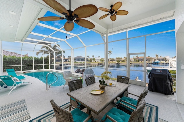 view of swimming pool featuring a water view, a grill, a lanai, and a patio