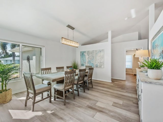 dining room featuring vaulted ceiling and light hardwood / wood-style floors