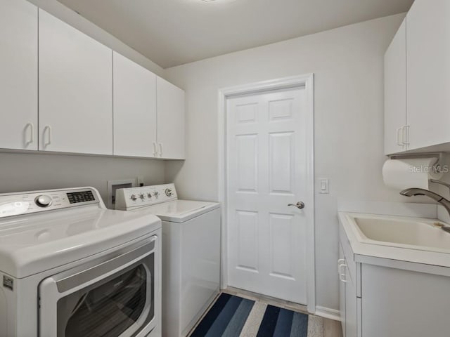 washroom featuring sink, cabinets, and washer and dryer