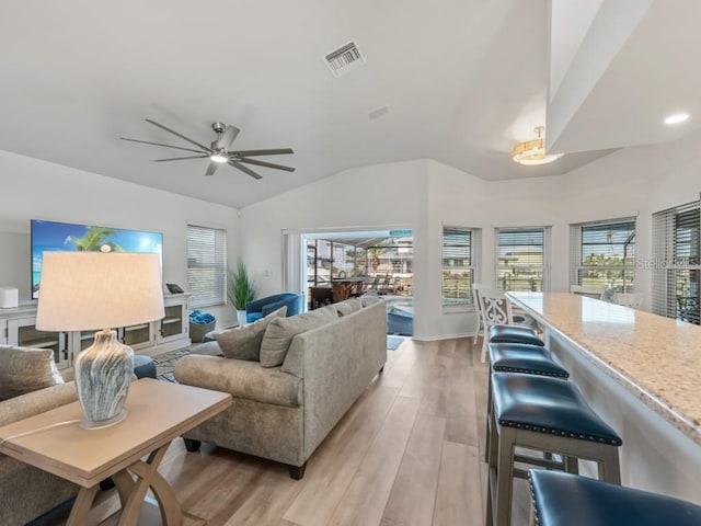 living room with ceiling fan, light hardwood / wood-style flooring, and lofted ceiling