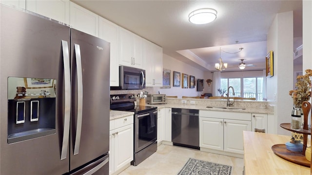 kitchen featuring white cabinets, appliances with stainless steel finishes, decorative light fixtures, sink, and kitchen peninsula