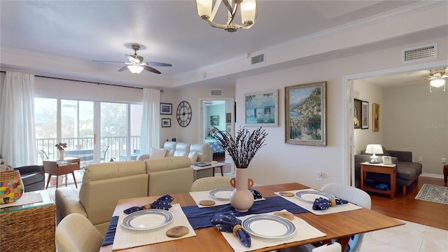 tiled dining area featuring ceiling fan with notable chandelier and ornamental molding