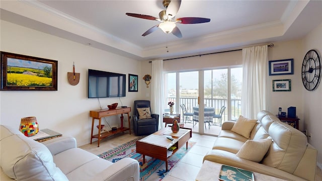 living room with crown molding, light tile patterned floors, ceiling fan, and a raised ceiling