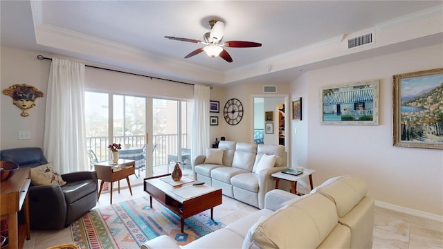 living room featuring ceiling fan, a tray ceiling, and ornamental molding