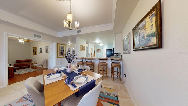 dining room with ceiling fan, a raised ceiling, and ornamental molding