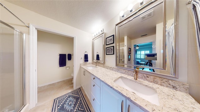 bathroom featuring a textured ceiling, toilet, vanity, and an enclosed shower