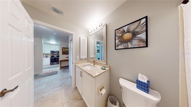 bathroom with decorative backsplash, a textured ceiling, toilet, and vanity