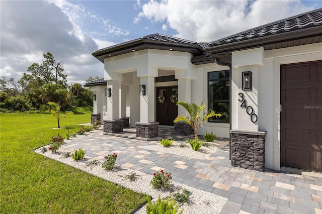 doorway to property with a lawn and french doors