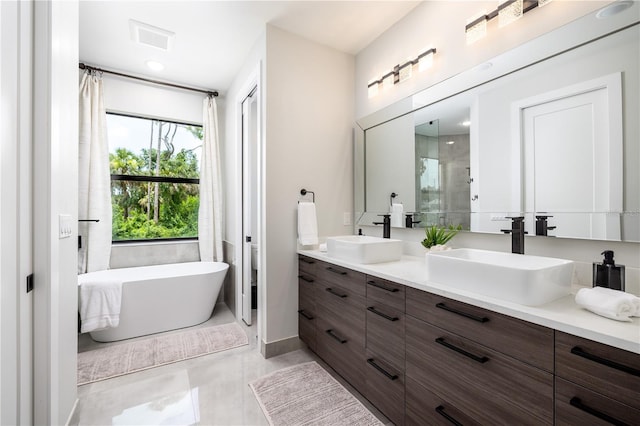 bathroom featuring vanity, independent shower and bath, and tile patterned flooring