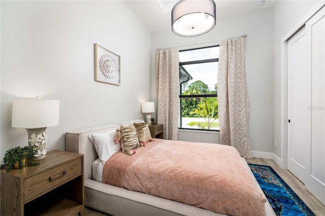 bedroom with light hardwood / wood-style flooring and a closet