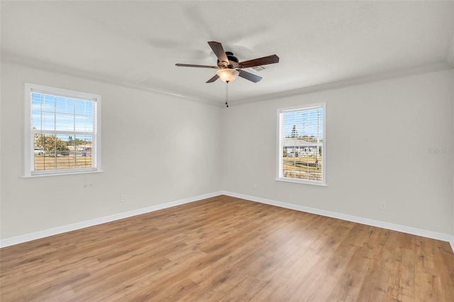 empty room with ceiling fan, ornamental molding, and light wood-type flooring