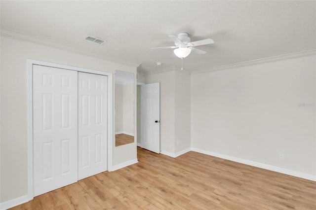 unfurnished bedroom featuring ornamental molding, light hardwood / wood-style flooring, ceiling fan, and a closet