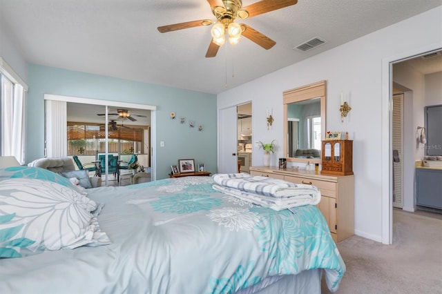 bedroom with a textured ceiling, light carpet, access to exterior, and ceiling fan