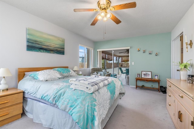 carpeted bedroom featuring ceiling fan and a textured ceiling