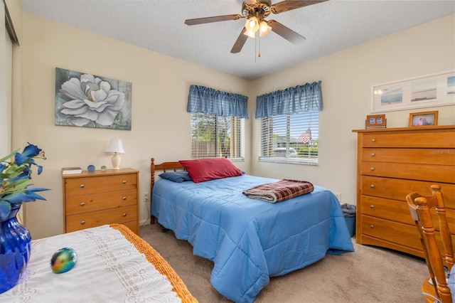 bedroom with light carpet, a textured ceiling, and ceiling fan