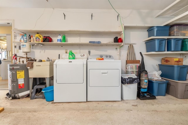 clothes washing area featuring electric water heater, sink, and washing machine and clothes dryer