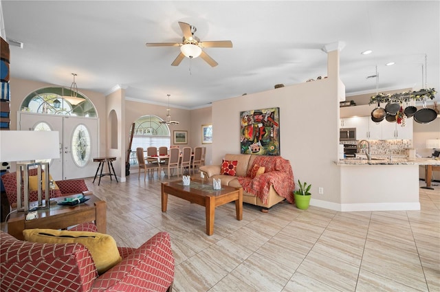 living room with sink, ceiling fan, and ornamental molding