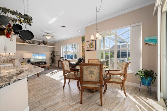 dining space with ceiling fan and crown molding