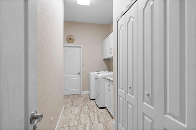 clothes washing area featuring cabinets and washing machine and dryer