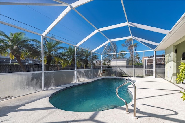 view of pool featuring glass enclosure and a patio area