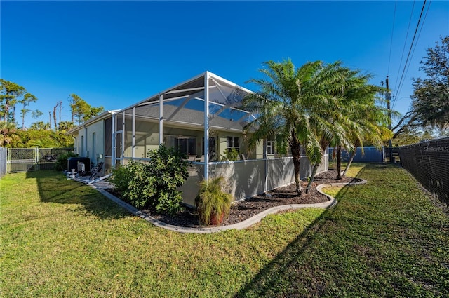 view of side of property featuring a lanai and a yard