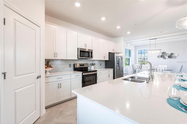 kitchen with stainless steel appliances, white cabinetry, sink, and decorative light fixtures