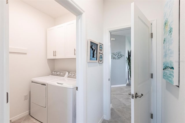 laundry room featuring cabinets, light tile patterned flooring, and separate washer and dryer