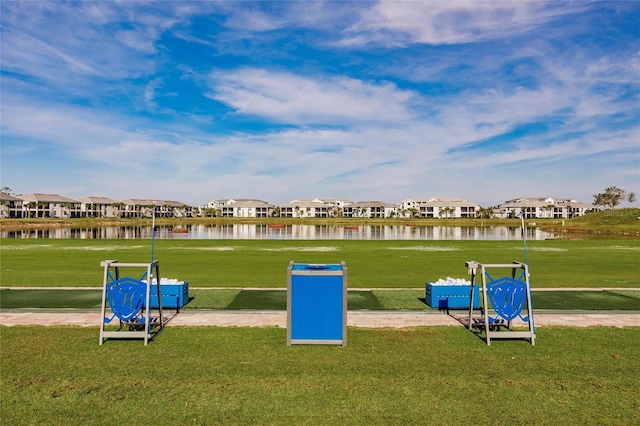 view of jungle gym featuring a water view and a lawn