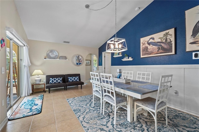 dining space with a notable chandelier, vaulted ceiling, and tile patterned floors