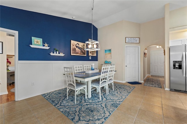 dining area with vaulted ceiling, a chandelier, and tile patterned flooring