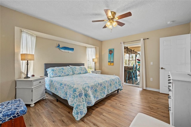 bedroom featuring a textured ceiling, light wood-type flooring, access to exterior, and ceiling fan