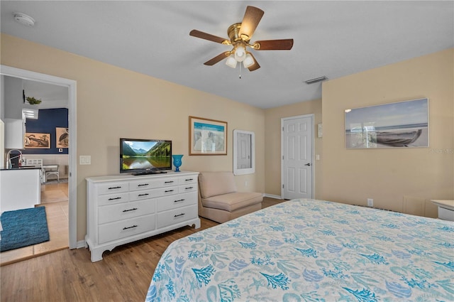 bedroom featuring ceiling fan, sink, and light wood-type flooring