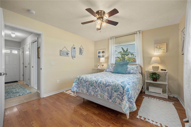 bedroom featuring ceiling fan, wood-type flooring, and a textured ceiling