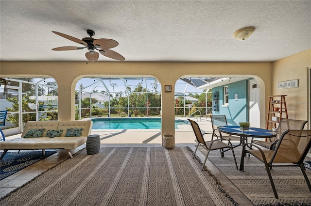 view of pool featuring ceiling fan, a lanai, and a patio