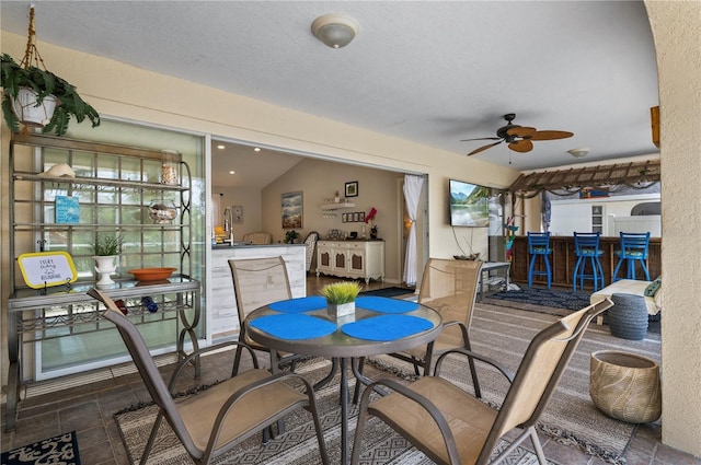 interior space featuring ceiling fan and a bar