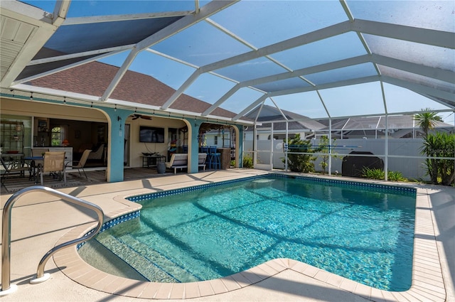 view of swimming pool with glass enclosure and a patio area