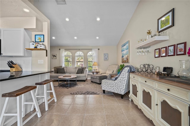 living room featuring light tile patterned floors, visible vents, recessed lighting, and lofted ceiling