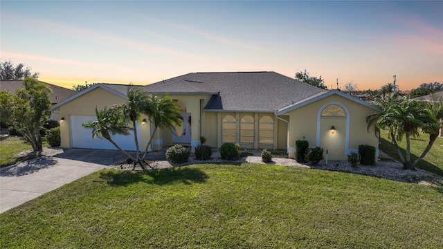 single story home with a garage and a lawn