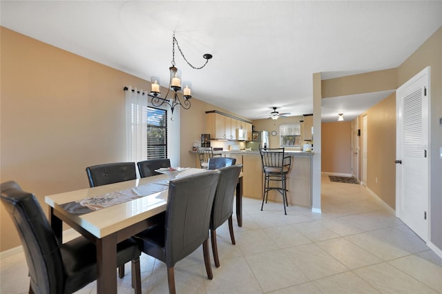 tiled dining area featuring ceiling fan with notable chandelier