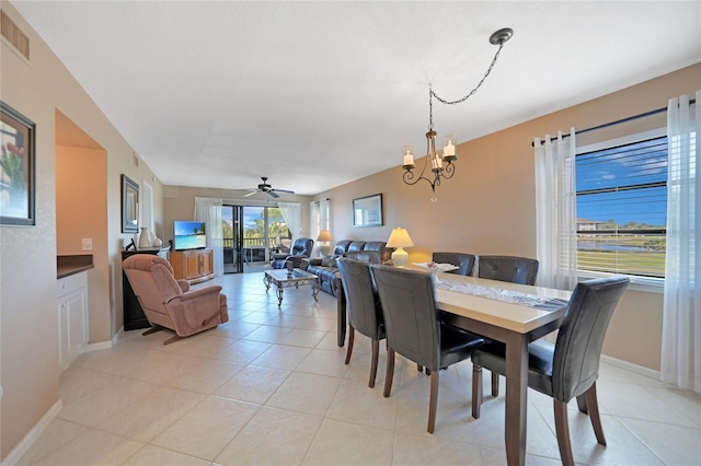 dining area featuring ceiling fan with notable chandelier and light tile patterned flooring