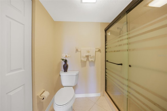 bathroom featuring toilet, an enclosed shower, and tile patterned flooring