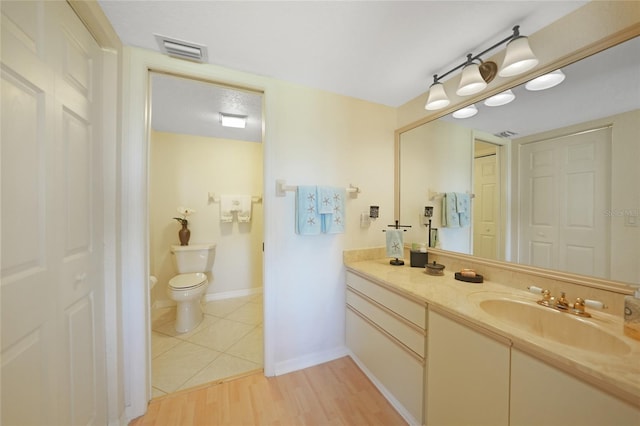 bathroom featuring wood-type flooring, vanity, and toilet