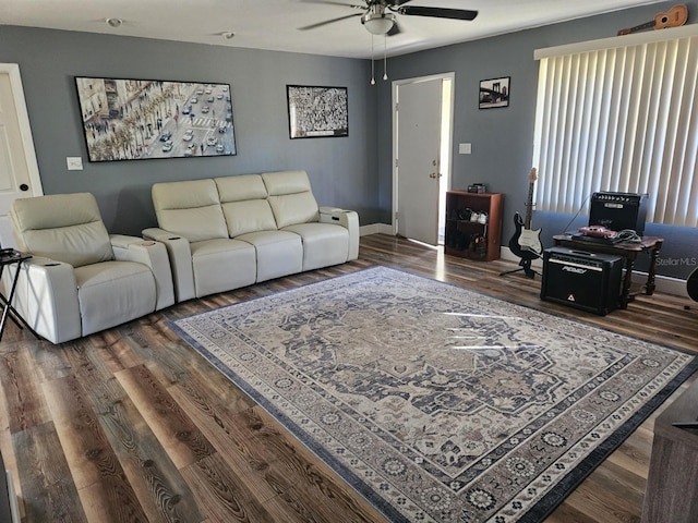 living room with dark wood-type flooring and ceiling fan