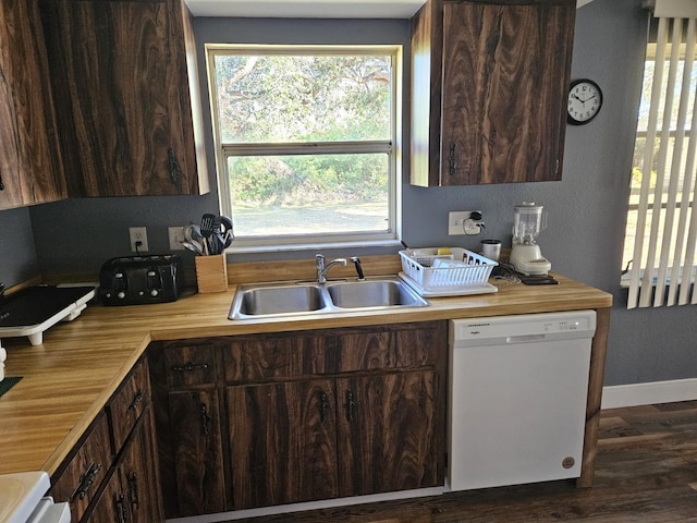 kitchen with white dishwasher, a sink, and dark brown cabinetry