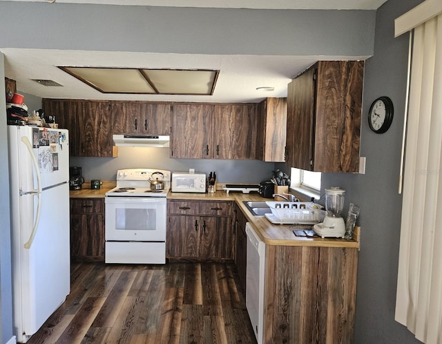 kitchen with white appliances, under cabinet range hood, dark wood-style floors, and light countertops