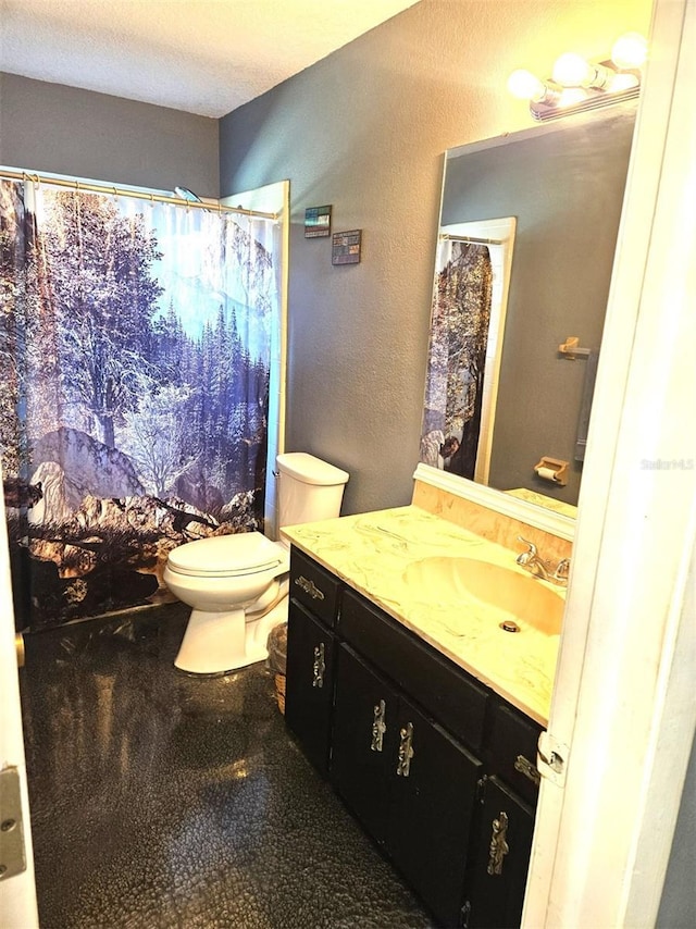 bathroom featuring a textured wall, a shower with shower curtain, toilet, vanity, and a textured ceiling