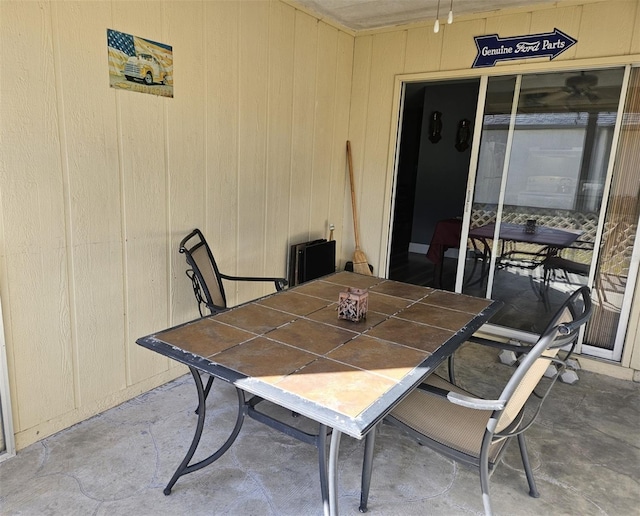 dining area with concrete floors and wooden walls